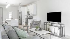 a living room with a couch and a tv at Landing Modern Apartment with Amazing Amenities (ID1011X798) in San Antonio
