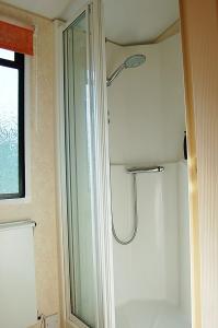un bagno con doccia e porta in vetro di Caravan 252 Bryn Y Mor Beach Side Park a Tywyn