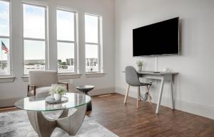 sala de estar con TV, mesa y sillas en Landing Modern Apartment with Amazing Amenities (ID5227) en Houston