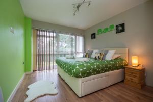 a bedroom with a bed with green walls and a window at Fairwinds in Sandbanks