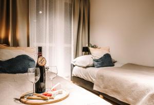 ストロニエ・シロンスキエにあるApartament Hutniczaのベッド2台、テーブル(ワイングラス付)が備わる客室です。