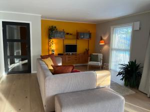 uma sala de estar com um sofá e uma televisão em Bosdalhuset em Lavik