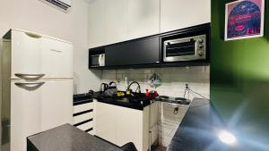 a kitchen with a white refrigerator and a microwave at Canoas Life - Comodidade e Piscina em São Conrado in Rio de Janeiro