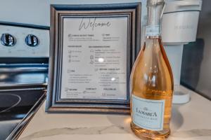 a bottle of wine sitting next to a framed menu at 1 BR 1 BA Luxury - Museum District & Downtown HTX in Houston
