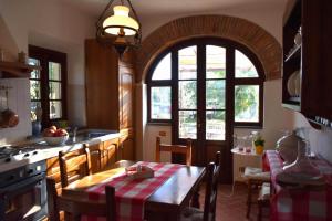 eine Küche mit einem Tisch und einem großen Fenster in der Unterkunft Casa Aia Sole with pool, A/C, garden, barbecue in Massarosa