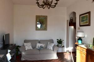 a living room with a couch and a chandelier at Casa Aia Sole with pool, A/C, garden, barbecue in Massarosa