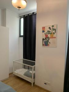 ein Zimmer mit einem Kinderbett in einem Schlafzimmer mit einem Fenster in der Unterkunft Athens Kolonaki Luxury Home in Athen
