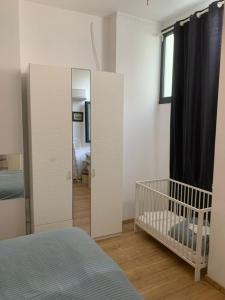 ein Schlafzimmer mit einem Kinderbett und einem Spiegel in der Unterkunft Athens Kolonaki Luxury Home in Athen