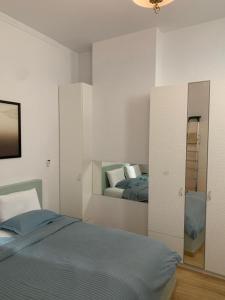 ein weißes Schlafzimmer mit einem Bett und einem Spiegel in der Unterkunft Athens Kolonaki Luxury Home in Athen