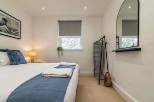 a bedroom with a large bed and a mirror at Affordable luxurious 3 bedroom 3 bathroom house great for contractors and large groups within 1 mile to City Centre with free parking in Nottingham
