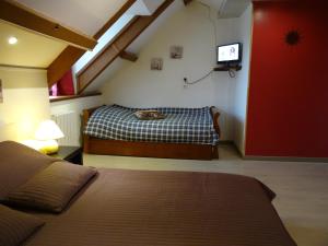 a bedroom with a bed and a tv on the wall at Datcha Bourguignonne, Chambres & Gîte in Maconge