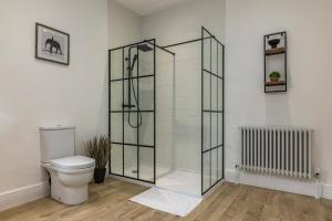 y baño con aseo y cabina de ducha de cristal. en Affordable luxurious 3 bedroom 3 bathroom house great for contractors and large groups within 1 mile to City Centre with free parking, en Nottingham