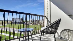 - un balcon avec deux chaises et une table dans l'établissement Landing Modern Apartment with Amazing Amenities (ID4336X27), à La Porte