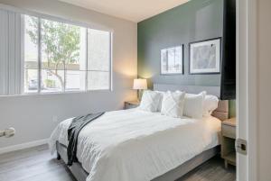 a bedroom with a large white bed with a window at Landing Modern Apartment with Amazing Amenities (ID4278) in Anthem