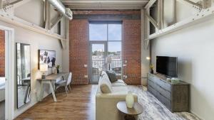 a living room with a couch and a tv at Landing Modern Apartment with Amazing Amenities (ID9909X36) in Omaha