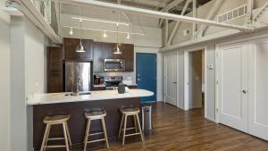 a kitchen with a counter and stools in a room at Landing Modern Apartment with Amazing Amenities (ID9909X36) in Omaha