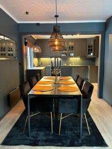 a dining room table with chairs and a kitchen at Rjukan Sentrum Apartments NO 1 in Rjukan