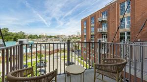 un balcón con 2 sillas y una mesa y un edificio en Landing Modern Apartment with Amazing Amenities (ID9909X36) en Omaha
