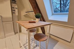 una mesa pequeña en una cocina con dos taburetes en Le perchoir, studio avec mezzanine en Arras