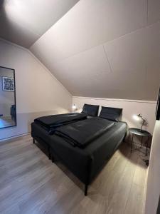 a bedroom with a large black bed in a room at Rjukan Sentrum Apartments NO 1 in Rjukan