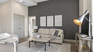 uma sala de estar com um sofá e uma mesa em Landing Modern Apartment with Amazing Amenities (ID6802X67) em Baltimore