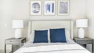 um quarto com uma cama com almofadas azuis e 2 candeeiros em Landing Modern Apartment with Amazing Amenities (ID6802X67) em Baltimore
