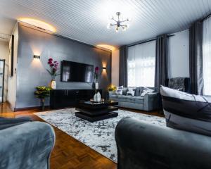 sala de estar con sofá y TV en African Oak: Rosewood en Arusha
