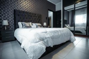 um quarto com uma grande cama branca e um espelho em African Oak: Rosewood em Arusha