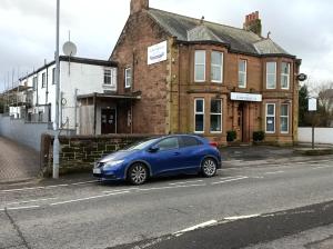 um carro azul estacionado ao lado de uma rua em The Townhouse Accommodation em Dumfries