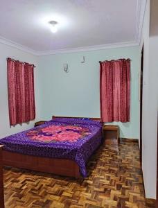 a bedroom with a purple bed and two windows at Relaxzen Homestay 2 in Kodaikānāl