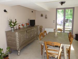 a dining room with a table and a television at Gite "la Solitude" in Licques
