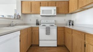 a kitchen with a white stove and a microwave at Landing Modern Apartment with Amazing Amenities (ID7807X89) in Wichita