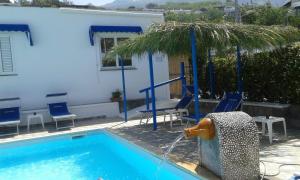 a swimming pool with blue chairs and a water fountain at Fantasy House 2.0 in Forio d'Ischia