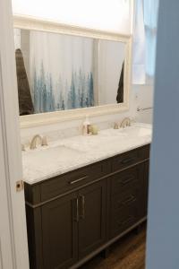 a bathroom with a sink and a large mirror at Central Tacoma Triplex in Tacoma