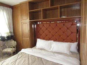 a bedroom with a bed with a wooden headboard at The guest house in Alexandria
