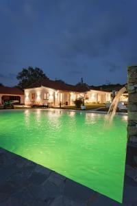 a swimming pool with a fountain in front of a house at Vila Julija 