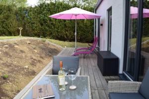a patio with a table and a pink umbrella at Naturgeflüster Chalet in Morbach
