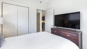 a bedroom with a large flat screen tv and a bed at Landing Modern Apartment with Amazing Amenities (ID6640) in Sandy