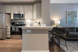 a kitchen with a counter and chairs in a room at Landing Modern Apartment with Amazing Amenities (ID5843) in Austin