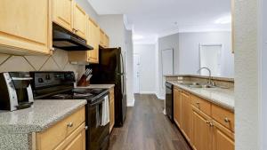 a kitchen with wooden cabinets and a stove top oven at Landing Modern Apartment with Amazing Amenities (ID2060X23) in Atlanta