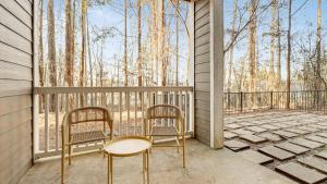 2 Stühle und ein Tisch auf einem Balkon mit Bäumen in der Unterkunft Landing Modern Apartment with Amazing Amenities (ID2060X23) in Atlanta
