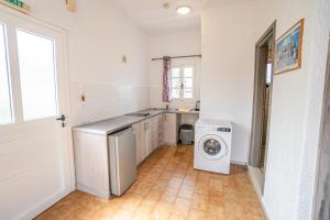 a kitchen with a washing machine and a washer at NORMA'S VILLAGE in Kalymnos