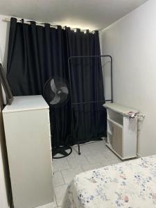 een slaapkamer met een zwart gordijn en een ventilator bij Pousada Beira Mar Centro São Pedro da Aldeia Rio de Janeiro in São Pedro da Aldeia