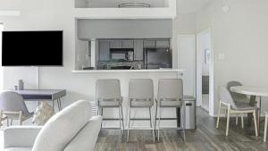 uma sala de estar branca com cadeiras e uma mesa em Landing Modern Apartment with Amazing Amenities (ID9400X06) em Dallas