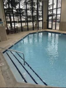 a large swimming pool with blue water in a building at Hampton Inn Ann Arbor - North in Ann Arbor
