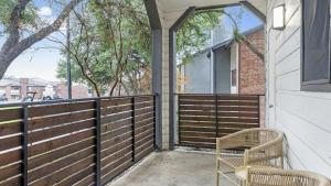 um alpendre com duas cadeiras e uma cerca em Landing Modern Apartment with Amazing Amenities (ID9400X06) em Dallas