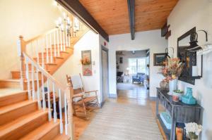 a hallway with a staircase and a living room at Paper Mill Pines Bed and Breakfast 