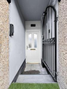 a white door in a white hallway with a green grass at Stylish Studio Suite w/ VIP lounge access - Maerdy 