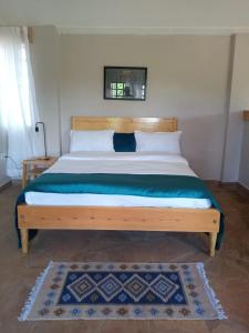 a bedroom with a large bed with a wooden headboard at KIJIJI VILLAGE in Emali