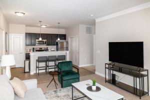 sala de estar con sofá y TV y cocina en Landing Modern Apartment with Amazing Amenities (ID5458) en Lewis Center